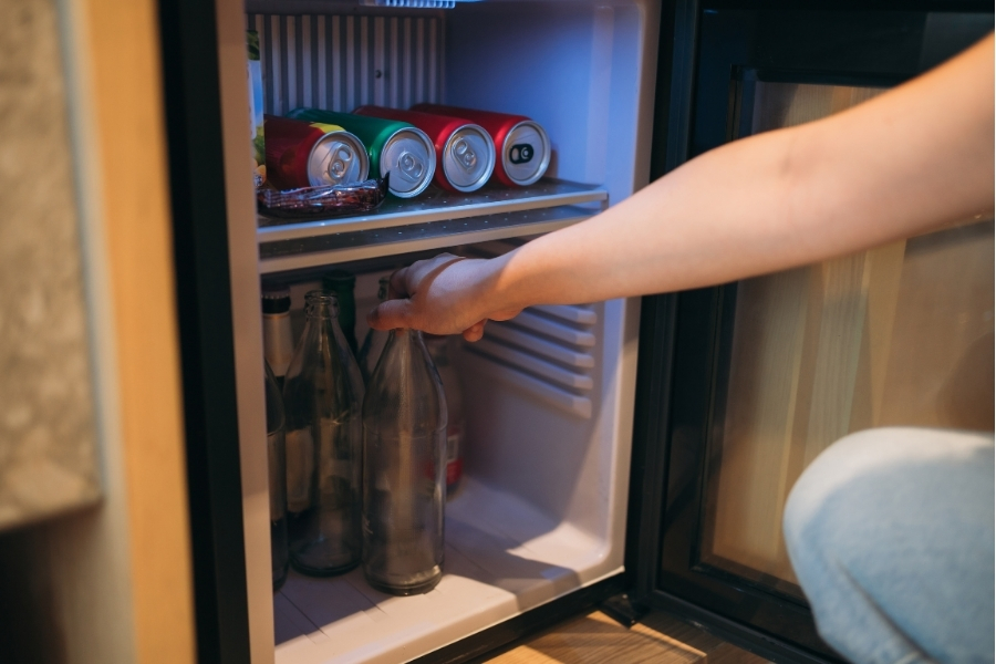 person cleaning mini fridge