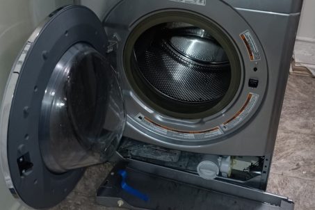 technicians replacing a washer's drain pump